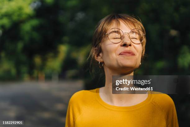 portrait of content young woman with closed eyes - alles hinter sich lassen stock-fotos und bilder