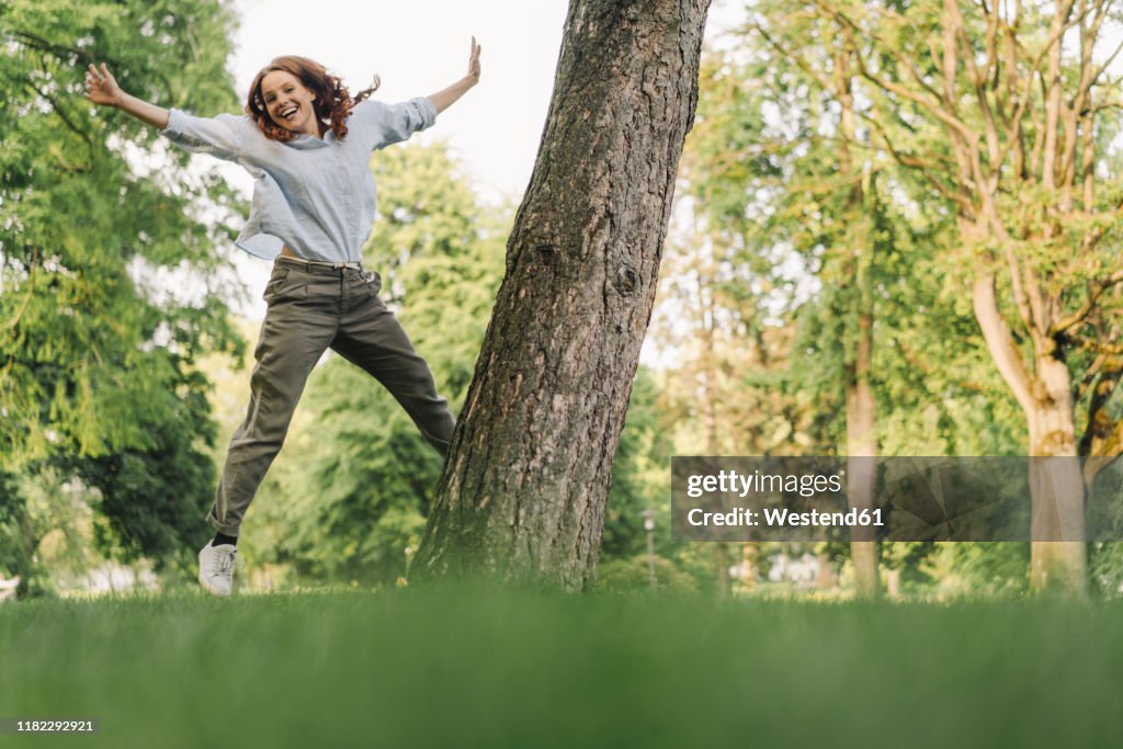 Portrait of happy redheaded woman in a park