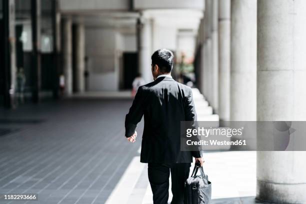rear view of young businessman walking in the city - business man walking with a bag in asia bildbanksfoton och bilder