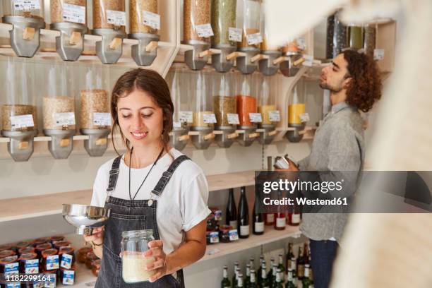 woman shopping in packaging-free supermarket - filling jar stock pictures, royalty-free photos & images