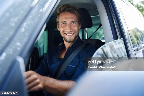 portrait of smiling young man in car - driver portrait stock pictures, royalty-free photos & images