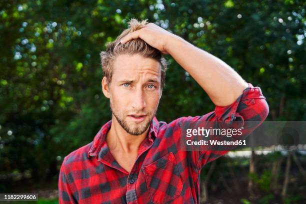 portrait of young man wearing checkered shirt outdoors - man wearing plaid shirt stock pictures, royalty-free photos & images