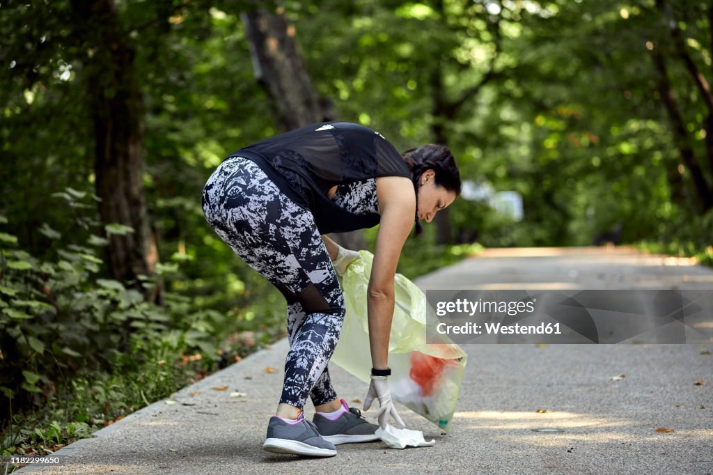 Young woman plogging on forest path