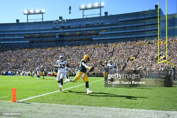 Jamaal Williams of the Green Bay Packers scores a touchdown during the second quarter against the Oakland Raiders in the game at Lambeau Field on...