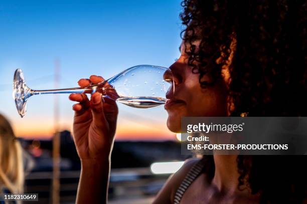 woman is drinking champagne on a rooftop party - champagne rooftop stock pictures, royalty-free photos & images