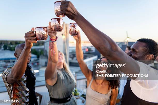 urban rooftop party - trendy group of people partying together - cocktail sommer stockfoto's en -beelden