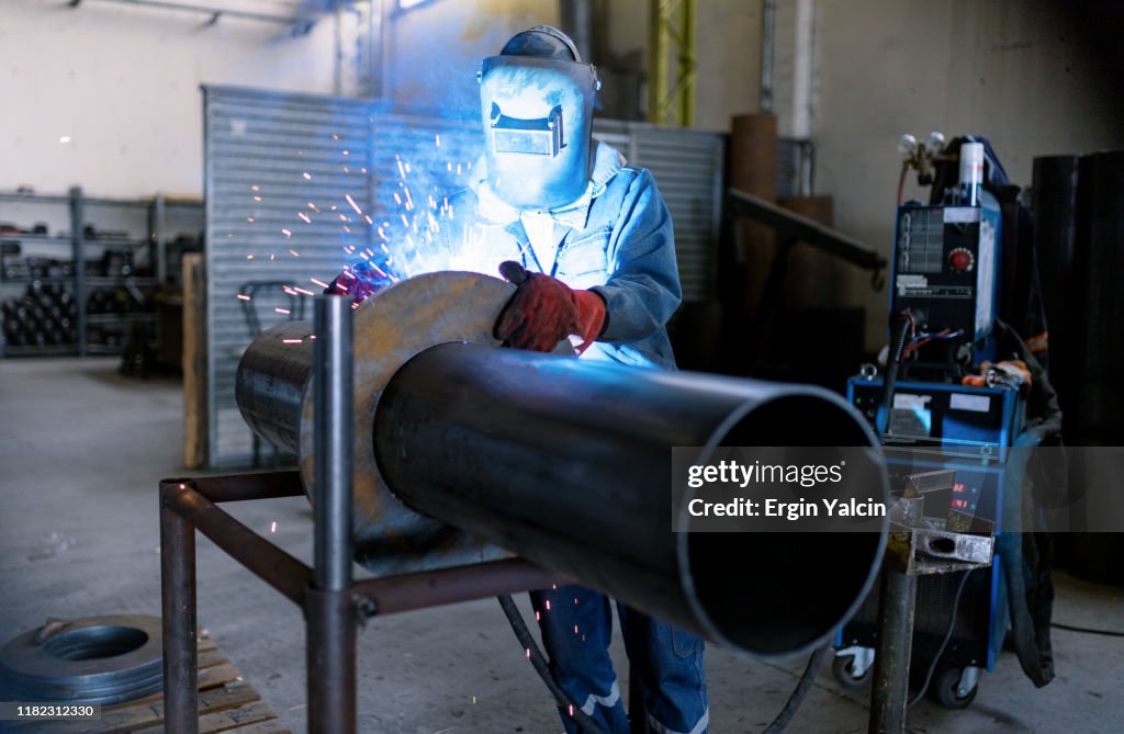 İndustrial worker welding on the pipe