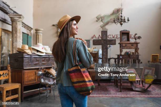 young woman shopping in antique store - designer handbag stockfoto's en -beelden