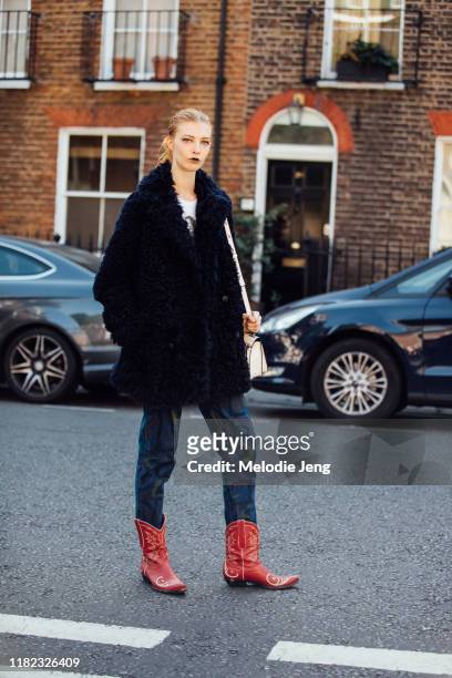 Model Remington Williams wears a blue fur jacket, blue graffiti jeans, and red cowboy boots after the Molly Goddard show during London Fashion Week...