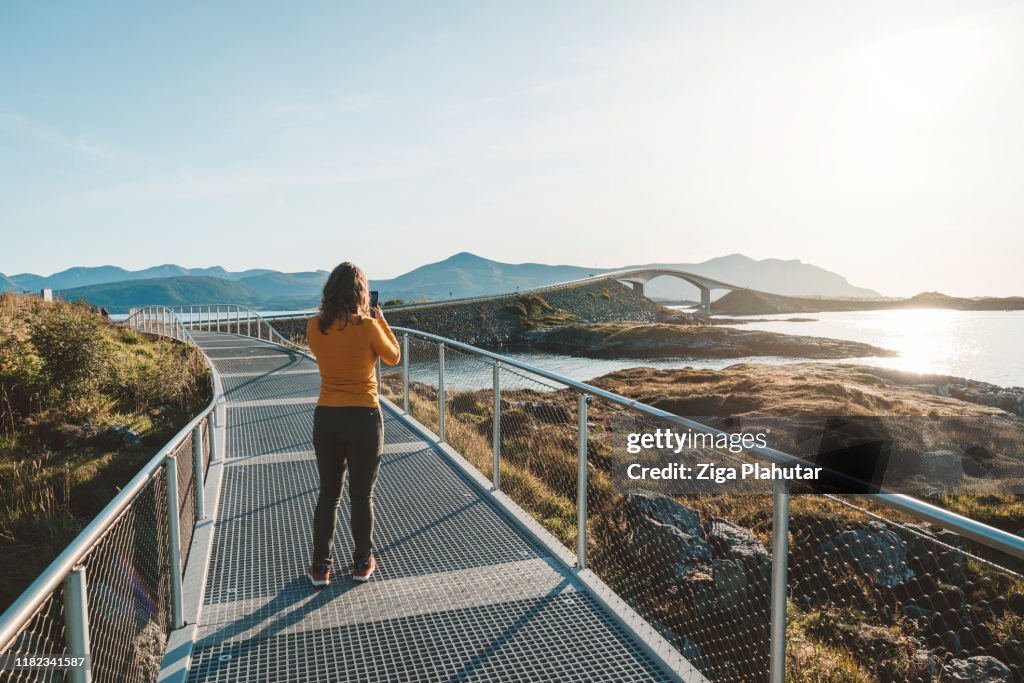 Woman taking a photo of Atlantic road in the distance