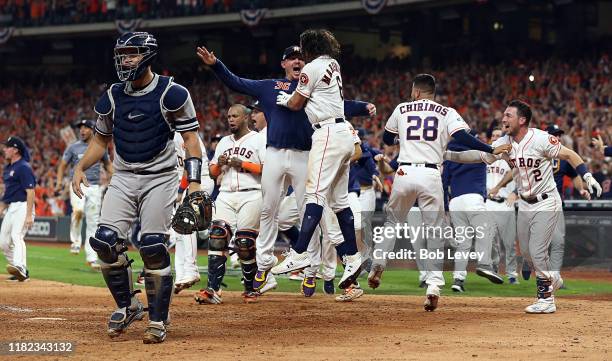 Gary Sanchez of the New York Yankees walks off the field as the Houston Astros celebrate a walkoff home run by Jose Altuve of the Houston Astros in...