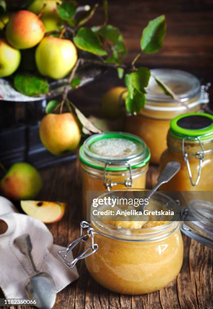 homemade apple sauce in jars on wooden rustic background - in konserve abfüllen stock-fotos und bilder