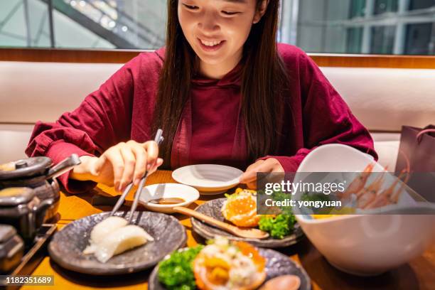 cheerful asian woman dining in a japanese restaurant - crab seafood stock pictures, royalty-free photos & images