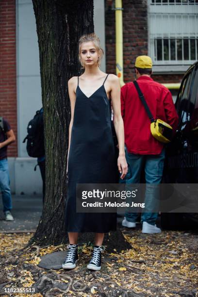 Model Liza Popova wears a black slip dress and black Converse sneakers after the Fendi show during Milan Fashion Week Spring/Summer 2020 on September...
