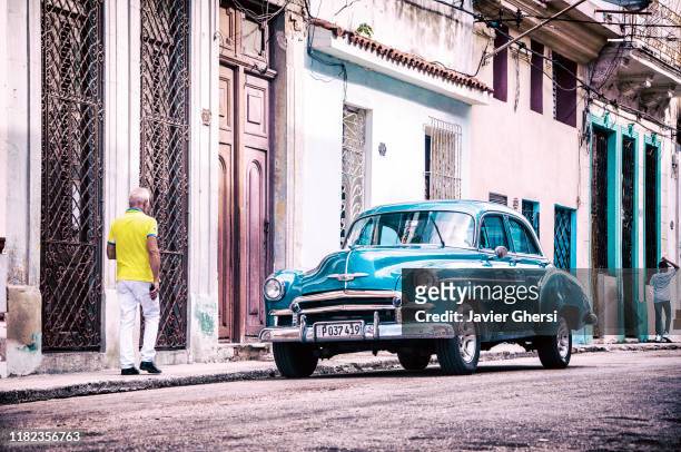 auto clásico y hombres caminando. la habana, cuba. - hombres caminando stock pictures, royalty-free photos & images