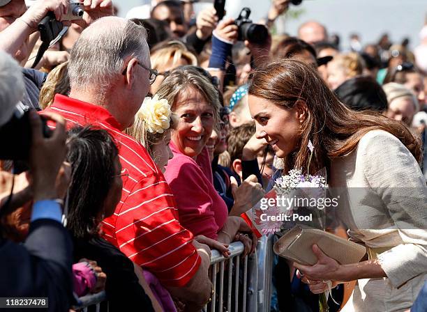 Catherine, the Duchess of Cambridge , greets a girl during a walkabout as she visits the Somba K'e Civic Plaza with her husband Prince William, Duke...