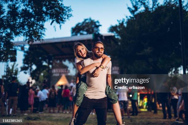 giro in piggyback in un festival musicale - popular music concert foto e immagini stock
