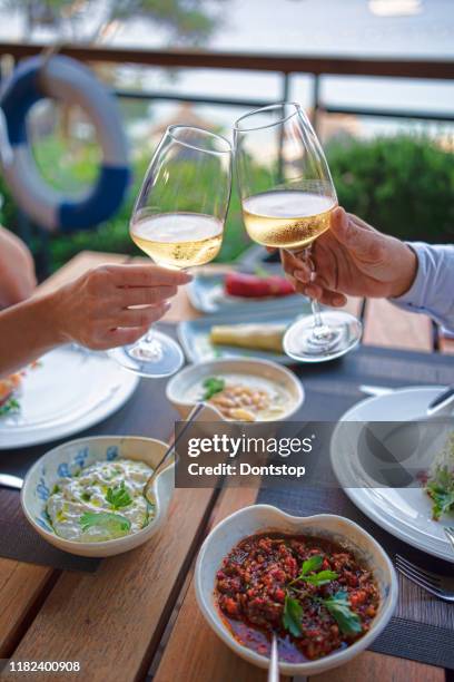 romantic dinner tables with champagne near the sea. - waterfront dining stock pictures, royalty-free photos & images