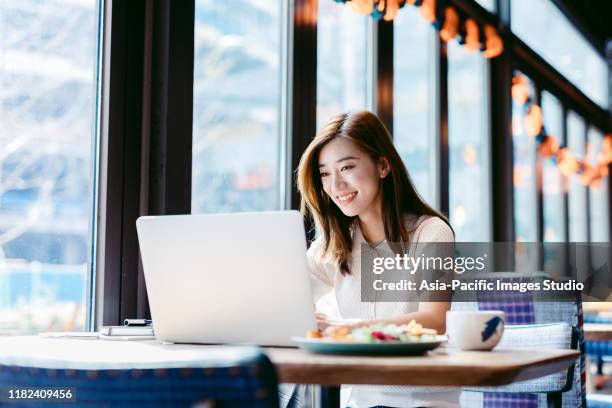asiatische frau arbeiten laptop im café. - cafe culture stock-fotos und bilder