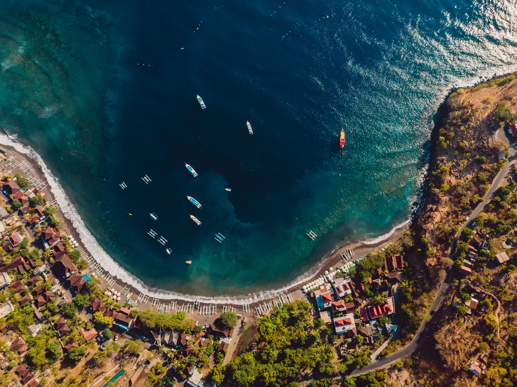 Aerial view of tourist town with blue sea water and boats, drone view in Amed, Bali Aerial view of tourist town with blue sea water and boats, drone view in Amed, Bali