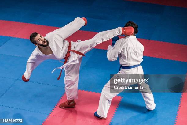 karate players competing during the match - karate stock pictures, royalty-free photos & images