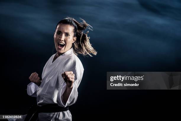 kvinnlig karate spelare utför karate hållning - gidräkt bildbanksfoton och bilder