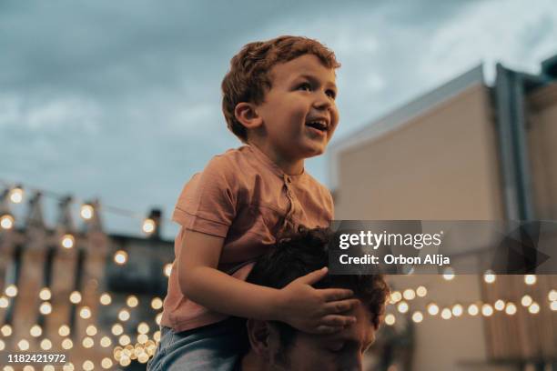 menino em um partido com luzes no fundo - papa noel - fotografias e filmes do acervo