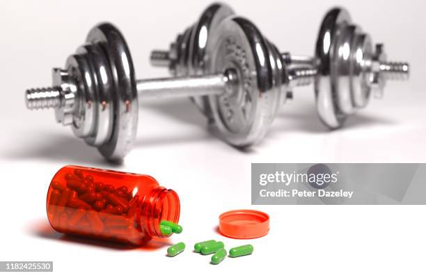 dumbbell weights in gym with pills - hormone photos et images de collection