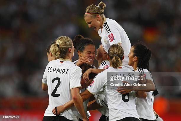 Celia Okoyino da Mbabi of Germany celebrates her team's fourth goal with team mates during the FIFA Women's World Cup 2011 Group A match between...