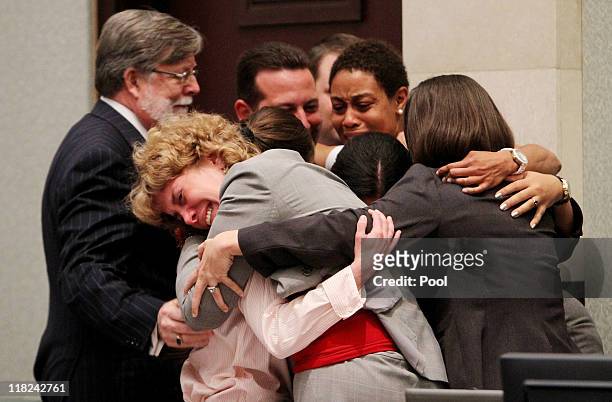 Defense attorney Dorothy Clay Sims, in gray jacket, hugs her client Casey Anthony, along with the rest of the defense team after Anthony was...