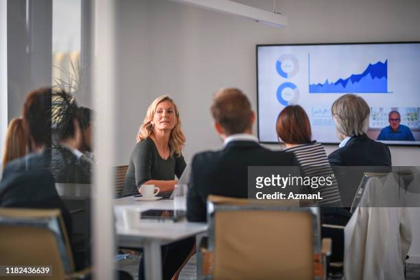 geschäftsfrau hört associate während videokonferenz zu - board room stock-fotos und bilder