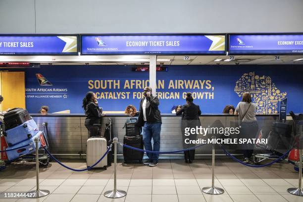 Travellers queue at a SAA info counter at the O.R. Tambo International Airport in Johannesburg, South Africa, on November 15, 2019. - The South...