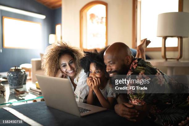 familia feliz viendo película en un ordenador portátil - familia viendo television fotografías e imágenes de stock