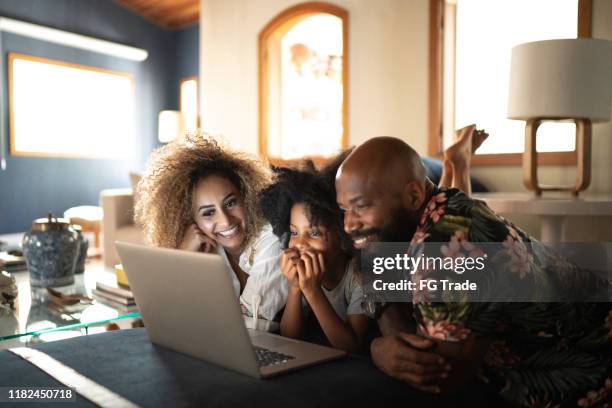 happy family watching movie on a laptop - criancas free imagens e fotografias de stock