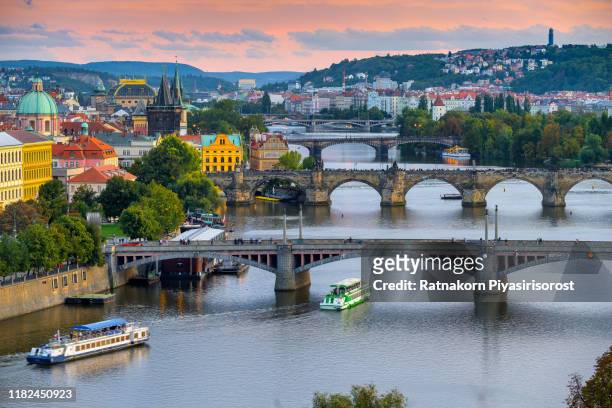 sunset scene of prague old town and charles bridge reflected in vltava river. prague, czech republic - vltava river stockfoto's en -beelden