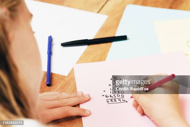 hand of a 12-year-old girl doing a long-multiplication sum for math homework - math homework stock pictures, royalty-free photos & images
