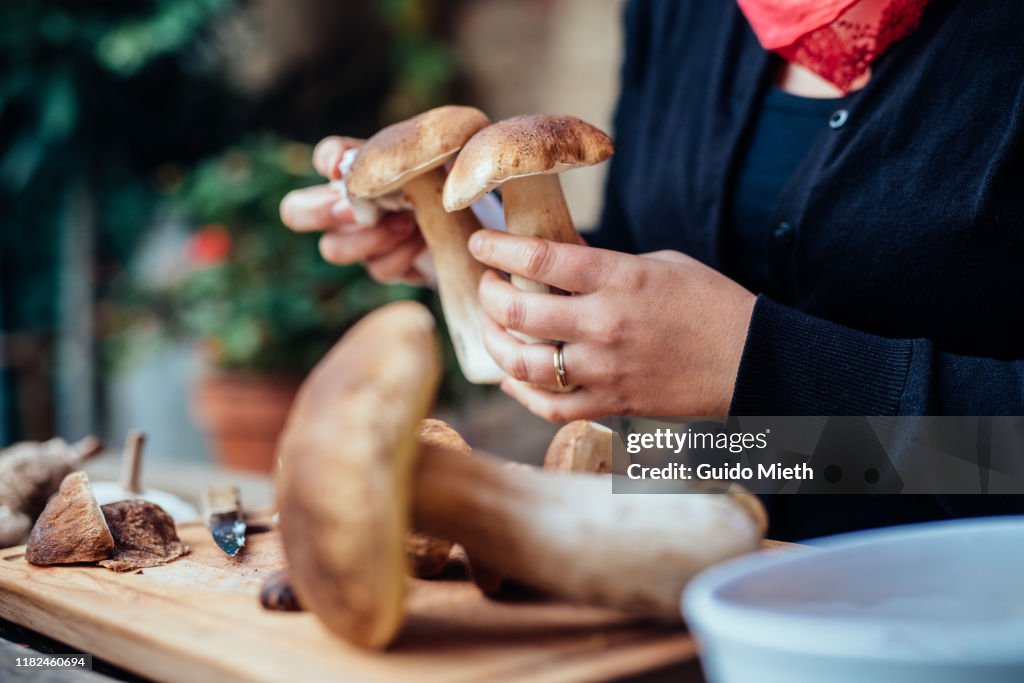 Woman cleaning big mushroom at home.
