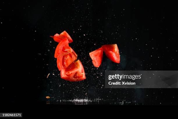 tomato slice flying in mid air captured with high speed sync. - zeitlupe stock-fotos und bilder
