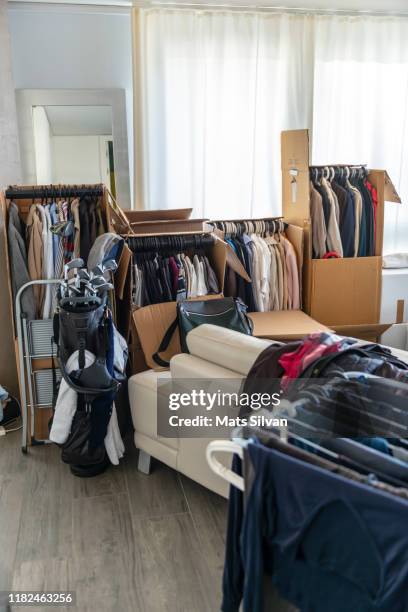 moving house with cardboard boxes and clothes and golf bag in living room - golf club house stock pictures, royalty-free photos & images