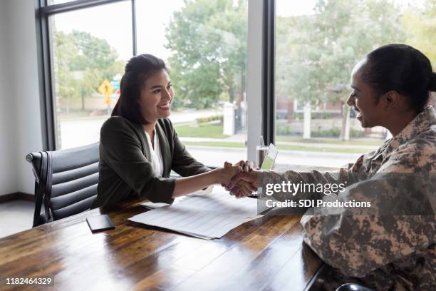 armee-veteran trifft sich mit finanzplaner - handshaking in a bank stock-fotos und bilder