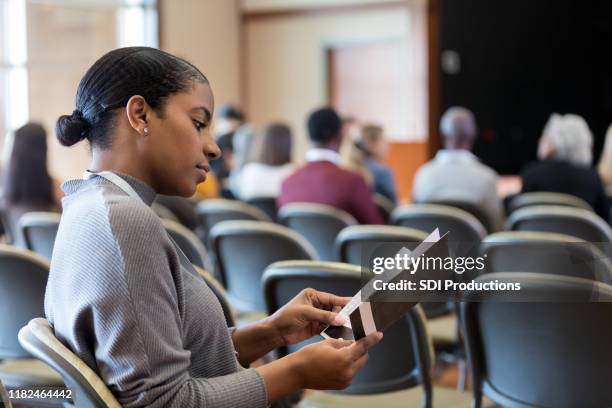 businesswoman reviews conference schedule - blank pamphlet stock pictures, royalty-free photos & images