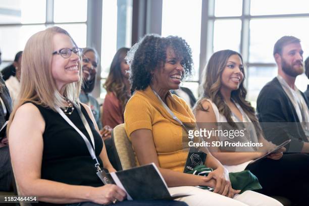 attente mensen glimlachen tijdens de conferentie - participant stockfoto's en -beelden