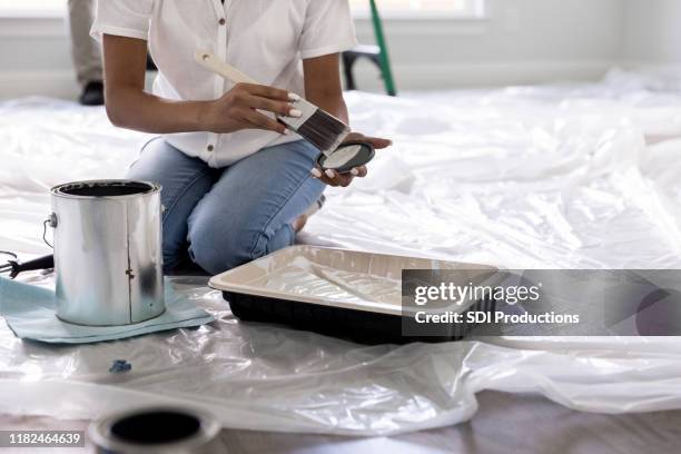 onherkenbaar vrouw schildert kamer - verfbak stockfoto's en -beelden