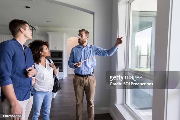 male real estate agent shows new home - agent imagens e fotografias de stock