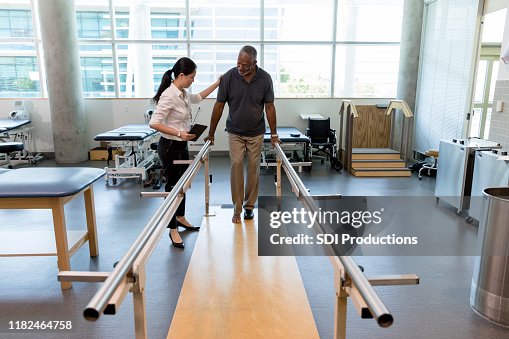 Physical therapist helps mature man take first steps after surgery