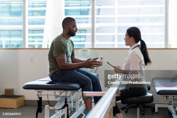 female doctor talks with injured soldier - injured us army stock pictures, royalty-free photos & images