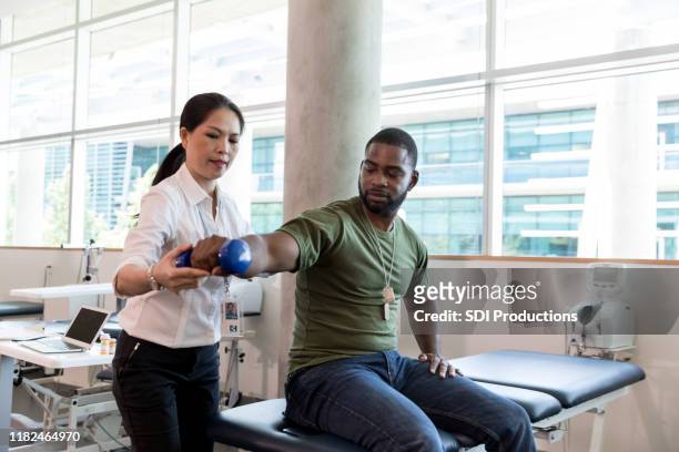 injured soldier in physical therapy - alternative therapy stock pictures, royalty-free photos & images