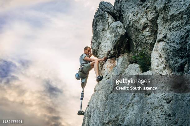 handicap man gratis rotsklimmen - prothesen stockfoto's en -beelden