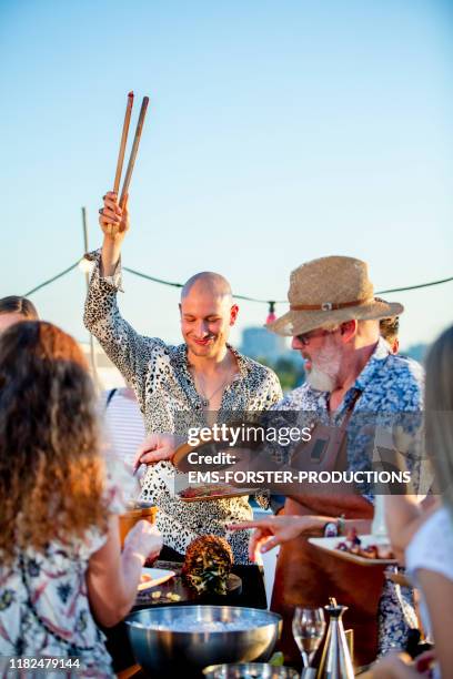 a group of friends helping themselves to food at a summer barbecue - afterwork photos et images de collection