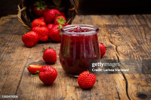 glas of homemade strawberry jam, strawberries, on dark wood - jam stock pictures, royalty-free photos & images